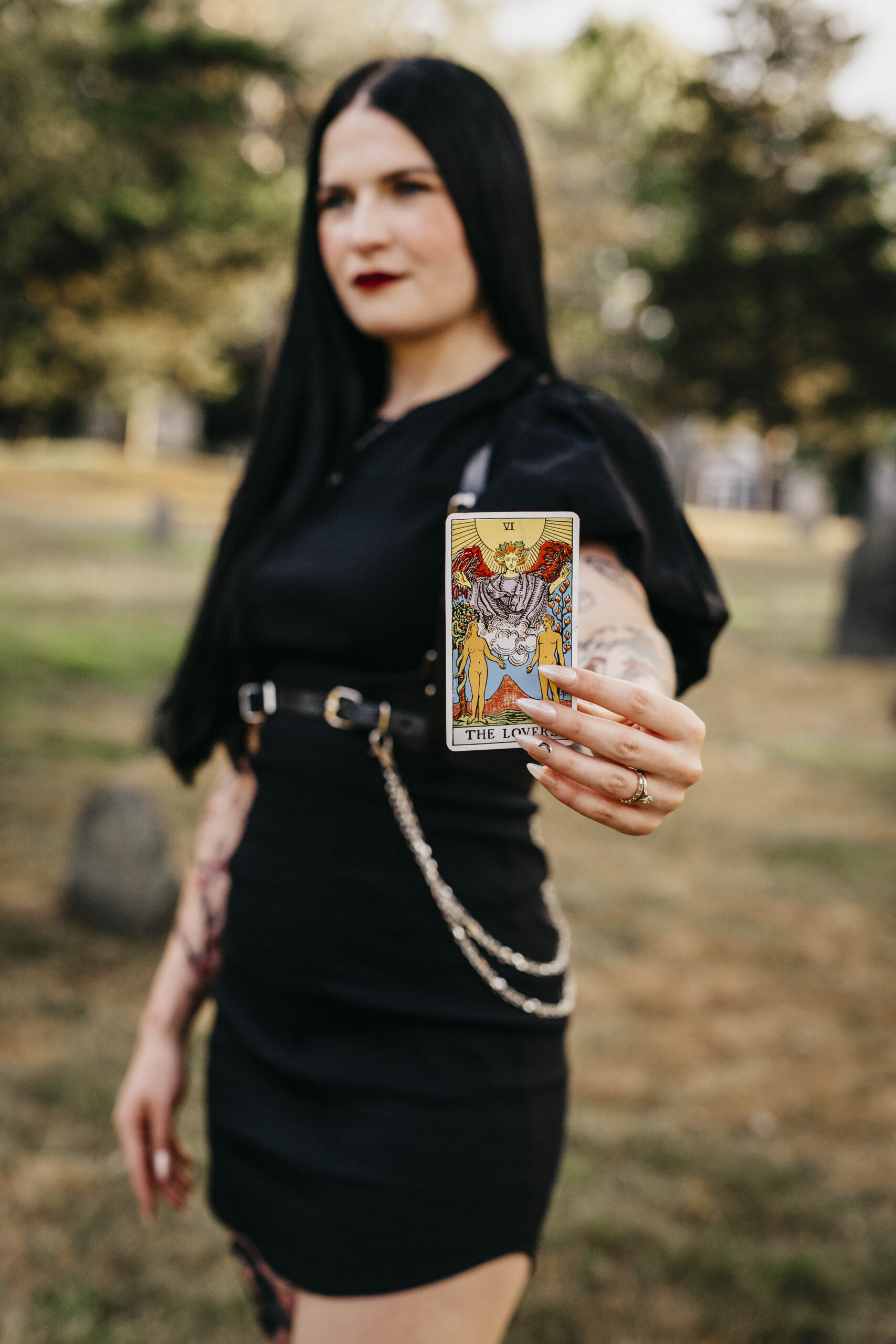 A bride poses with a tarot card in a cemetery in Salem Massachusetts