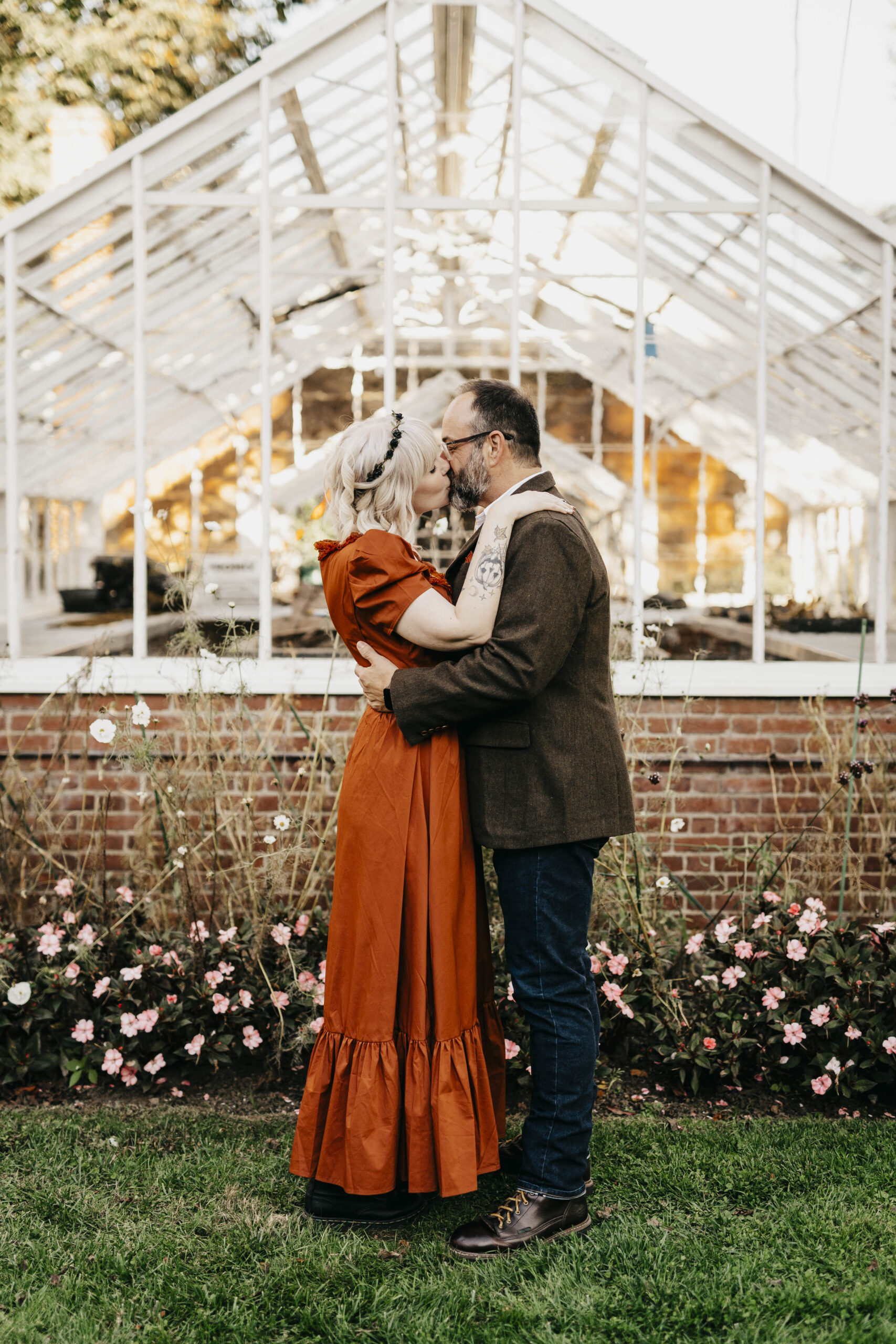 bride and groom kissing in front of the green house at the ropes mansion garden