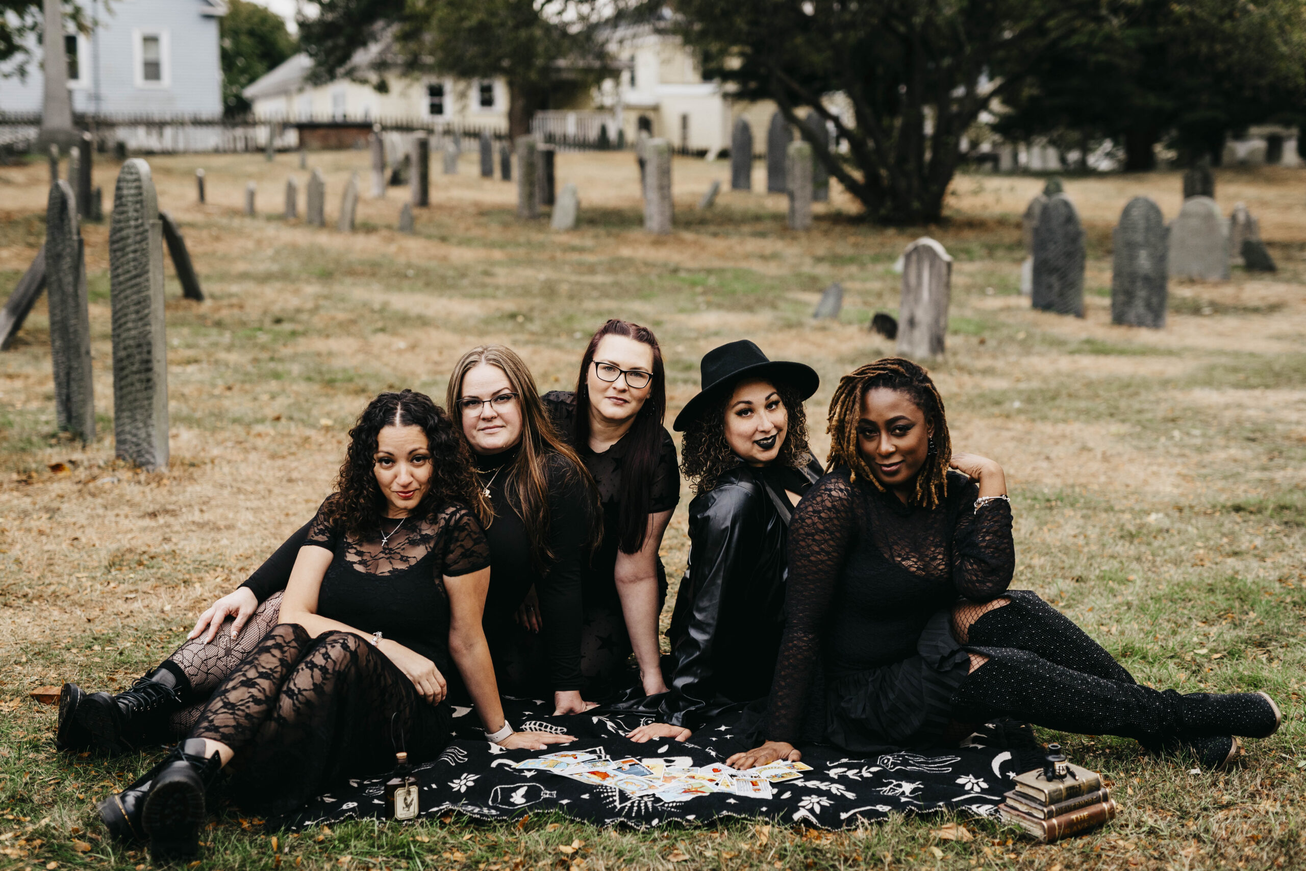 group of girls posing on picnic blanket in cemetery in salem massachusetts