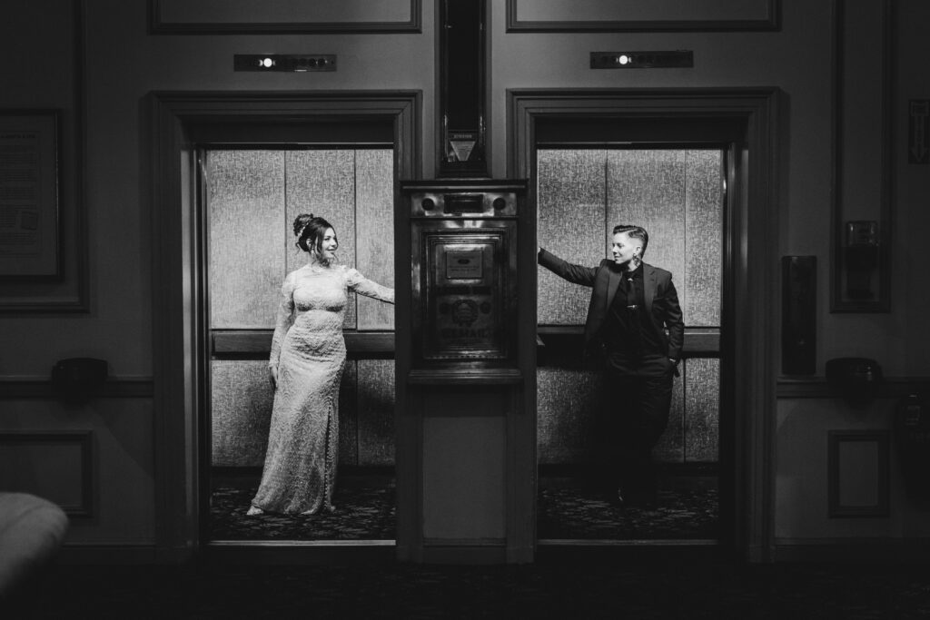 a black and white photo of two brides looking at each other in separate elevators at the Hawthorne Hotel in Salem Massachusetts