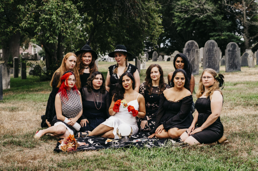 A group of girls sitting on a picnic blanket at a cemetery in Salem Massachusetts
