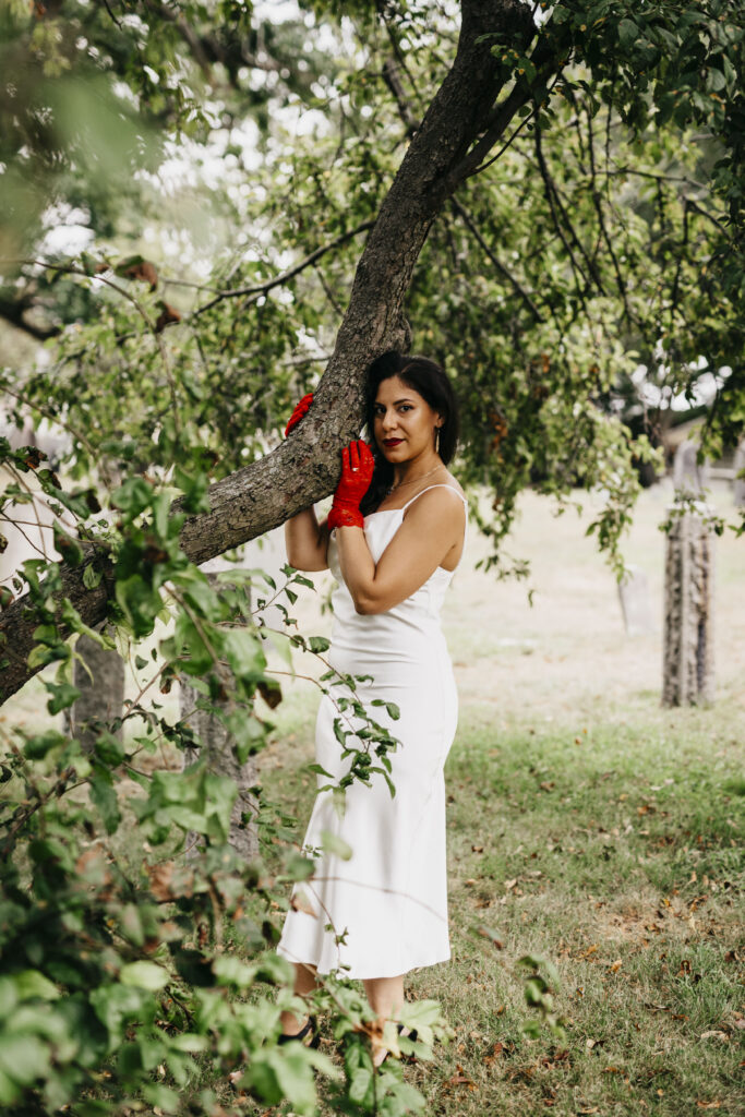 A bride poses under a tree at a cemetery in Salem Massachusetts
